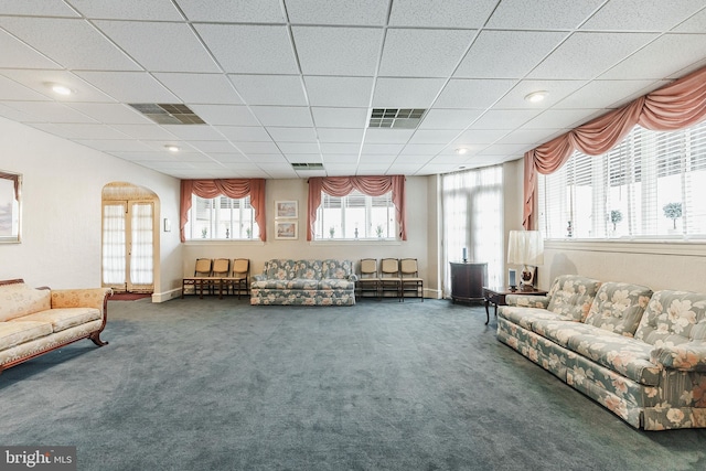 carpeted living room featuring a drop ceiling