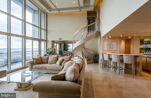 living room featuring a wall of windows, light tile floors, and a high ceiling