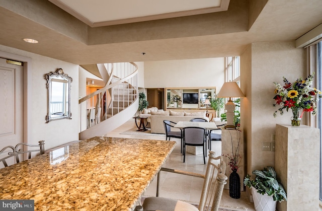 interior space featuring plenty of natural light, light tile floors, and light stone counters