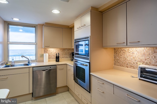 kitchen featuring backsplash, a healthy amount of sunlight, appliances with stainless steel finishes, and light tile floors