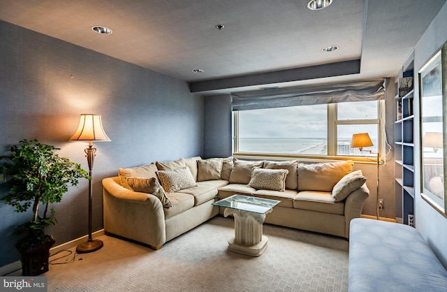 carpeted living room with a water view