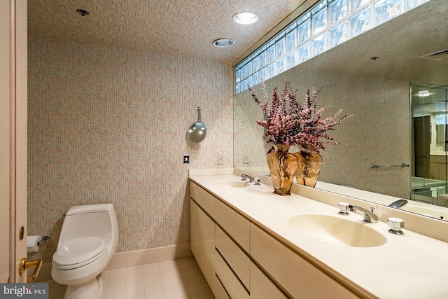 bathroom featuring tile floors, toilet, double sink, and large vanity