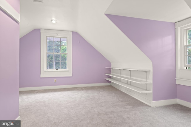 bonus room with light colored carpet, lofted ceiling, and a healthy amount of sunlight