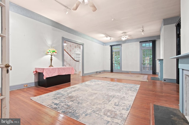 living area with light hardwood / wood-style floors, ceiling fan, and track lighting