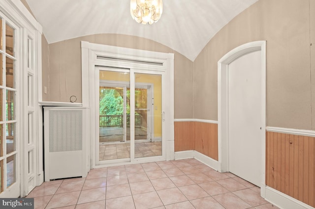 entryway featuring a notable chandelier, light tile floors, and lofted ceiling