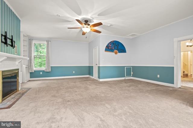 unfurnished living room with light carpet, ornamental molding, and ceiling fan with notable chandelier