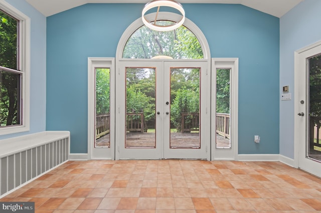 doorway with vaulted ceiling, french doors, and light tile floors