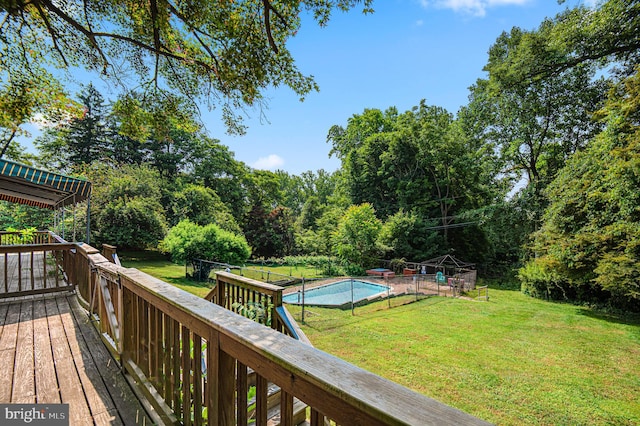 wooden deck featuring a lawn