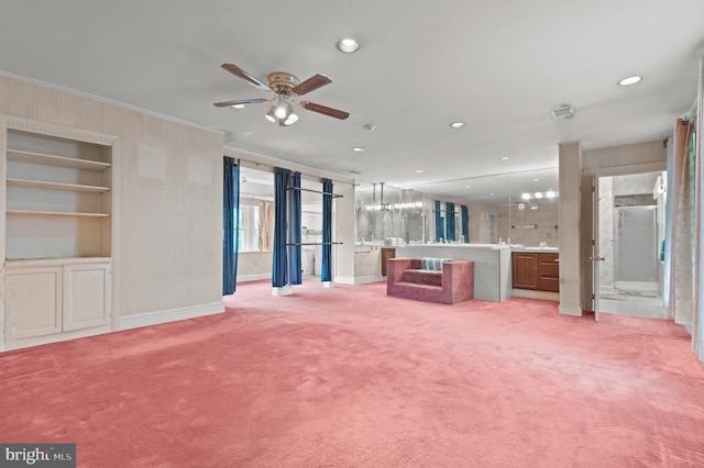 unfurnished living room with light carpet, built in features, and ceiling fan