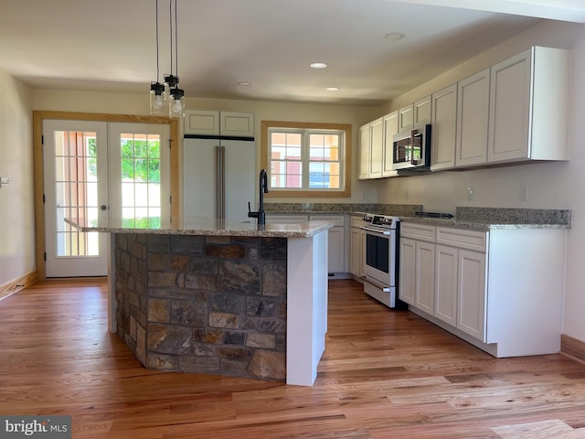 kitchen featuring pendant lighting, white cabinets, and stainless steel appliances