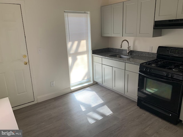 kitchen featuring black range with gas stovetop, white cabinetry, light hardwood / wood-style flooring, and sink