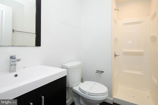 bathroom with walk in shower, large vanity, and toilet