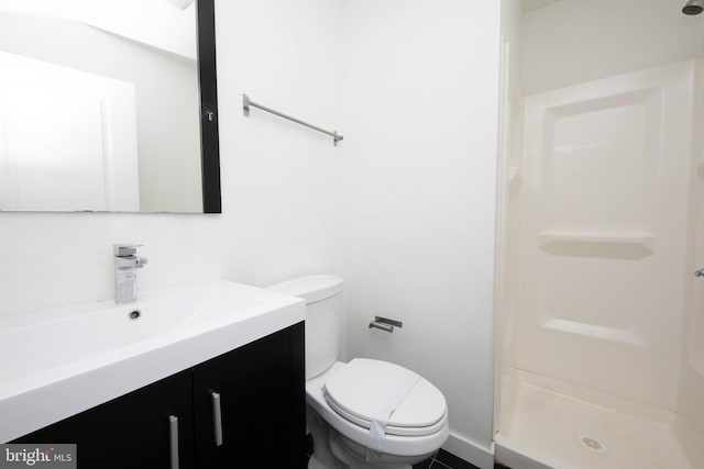 bathroom with a shower, vanity, tile floors, and toilet