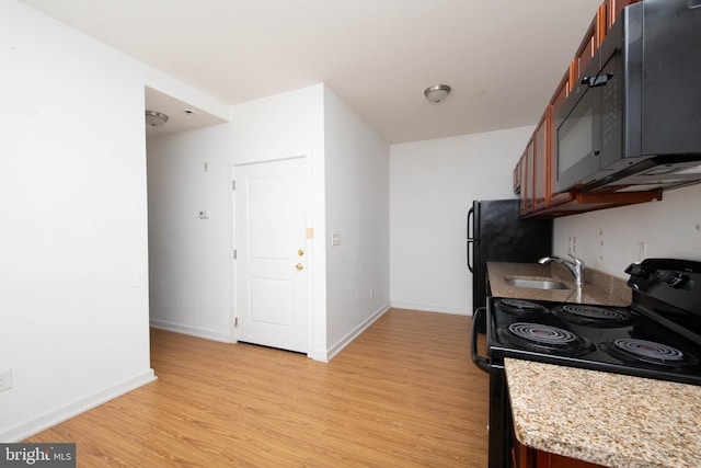 kitchen with sink, electric stove, light wood-type flooring, and light stone counters