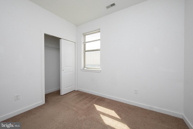 unfurnished bedroom with a closet and dark colored carpet