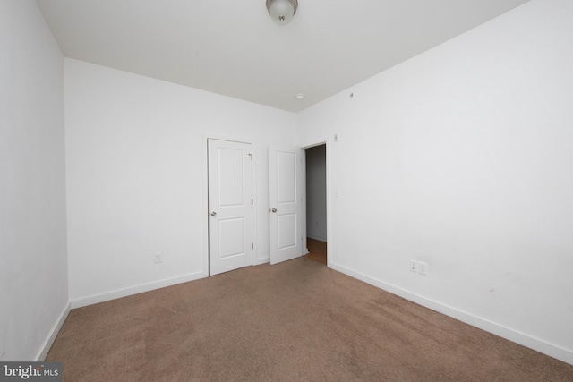 unfurnished bedroom with dark colored carpet