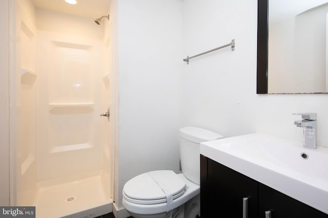 bathroom with walk in shower, vanity, and toilet