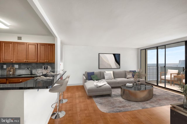 living room featuring a wall of windows and sink