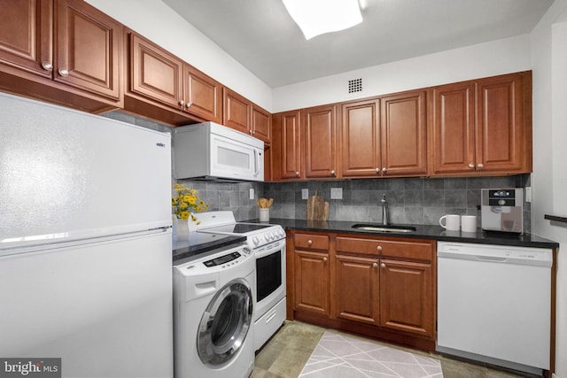 kitchen with sink, white appliances, backsplash, and washer / clothes dryer