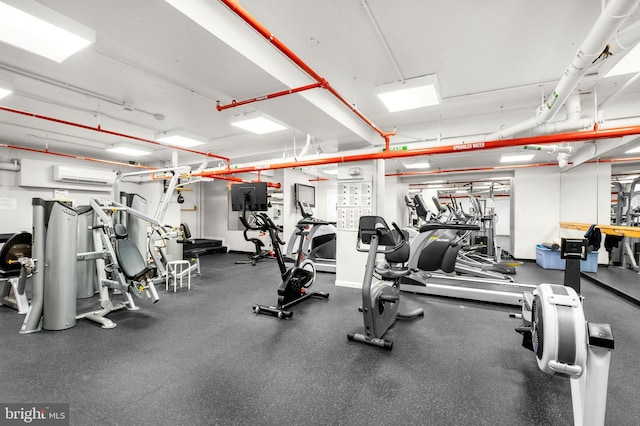 workout area featuring a wall mounted air conditioner