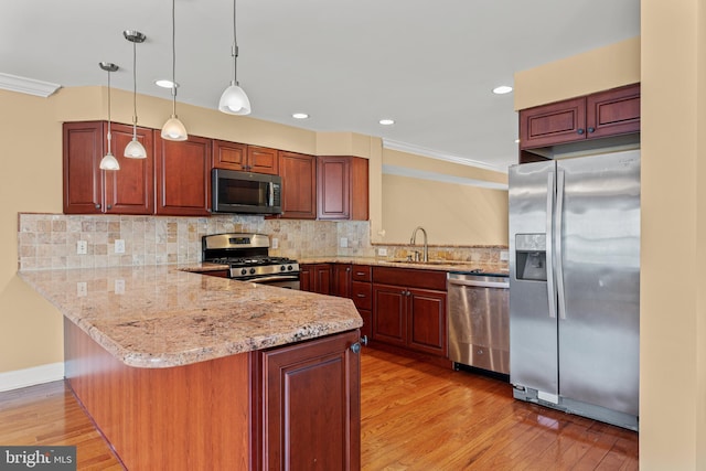 kitchen featuring backsplash, light hardwood / wood-style flooring, stainless steel appliances, and kitchen peninsula