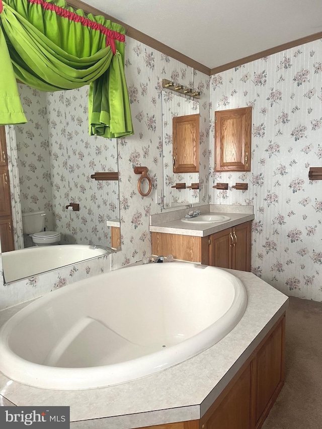 bathroom with toilet, vanity, a washtub, and ornamental molding