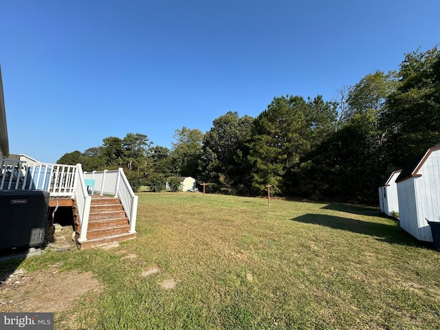 view of yard featuring central AC and a deck