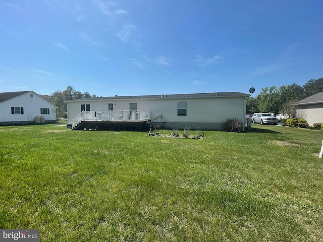 back of property with a wooden deck and a yard