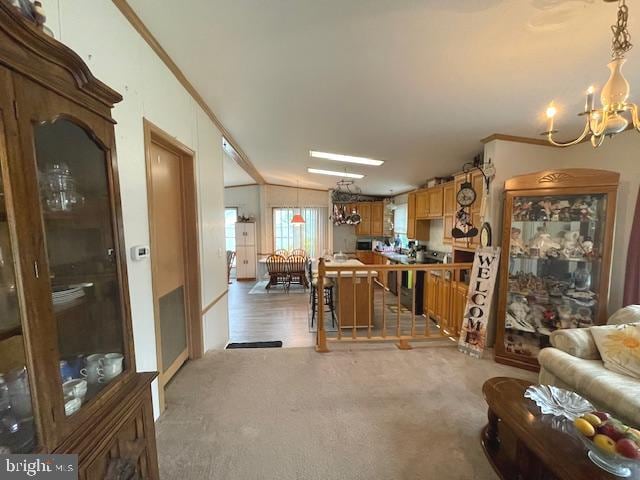 kitchen featuring a notable chandelier, decorative light fixtures, vaulted ceiling, carpet flooring, and crown molding