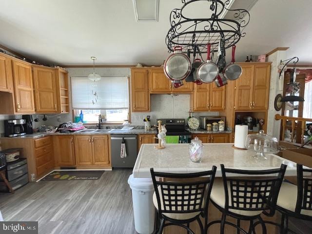 kitchen with dishwasher, a kitchen island, dark wood-type flooring, hanging light fixtures, and black electric range