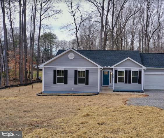 ranch-style house with a garage and a front lawn