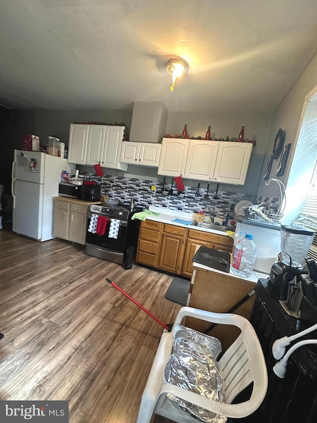 kitchen with range with electric cooktop, tasteful backsplash, white cabinets, hardwood / wood-style floors, and white refrigerator