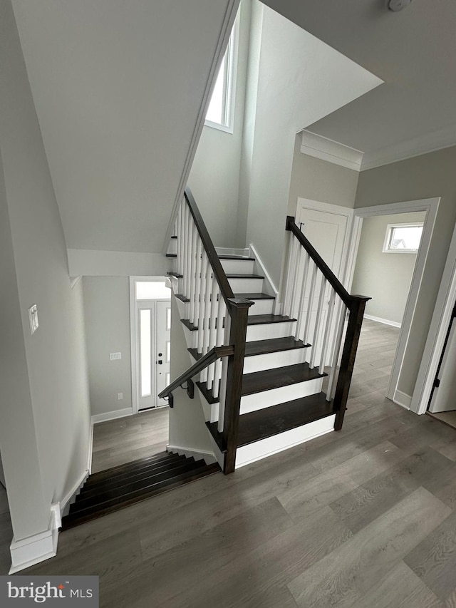 stairs featuring hardwood / wood-style flooring and crown molding