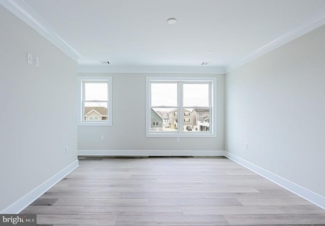 empty room featuring crown molding and light hardwood / wood-style floors