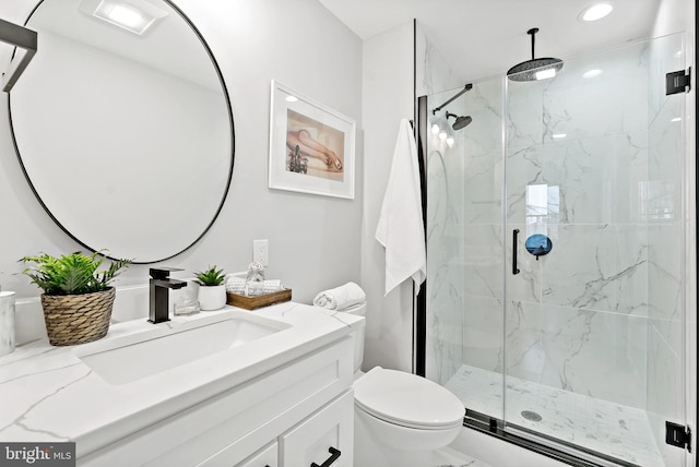 bathroom featuring walk in shower, vanity, and toilet