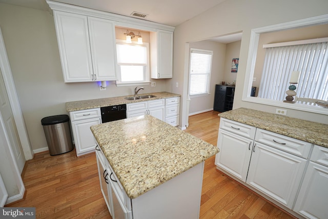 kitchen with sink, light hardwood / wood-style floors, dishwasher, and light stone counters