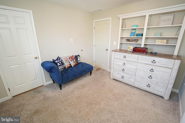 sitting room featuring light carpet