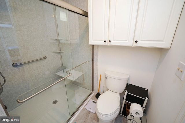 bathroom with a shower with shower door, toilet, and tile flooring