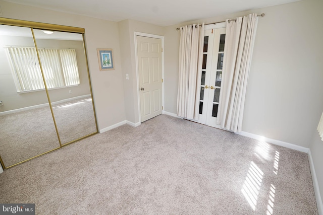 unfurnished bedroom featuring light colored carpet and a closet