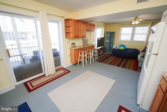 kitchen featuring white refrigerator, light colored carpet, and ceiling fan