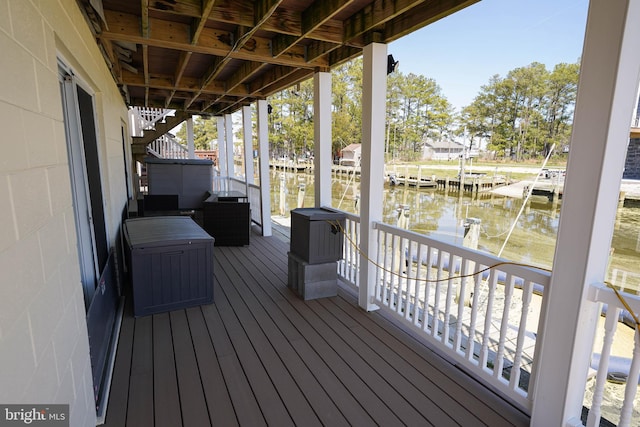 wooden terrace featuring a water view and a dock