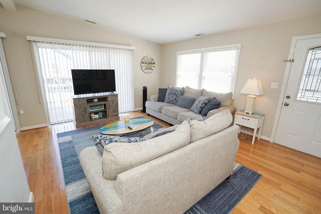 living room with lofted ceiling and light wood-type flooring