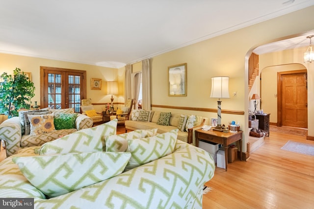 living room featuring light wood-type flooring, crown molding, and french doors