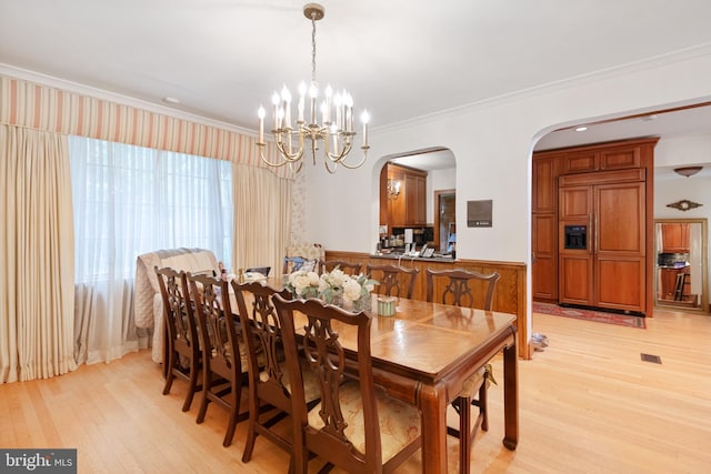 dining room with a chandelier, light hardwood / wood-style flooring, and crown molding