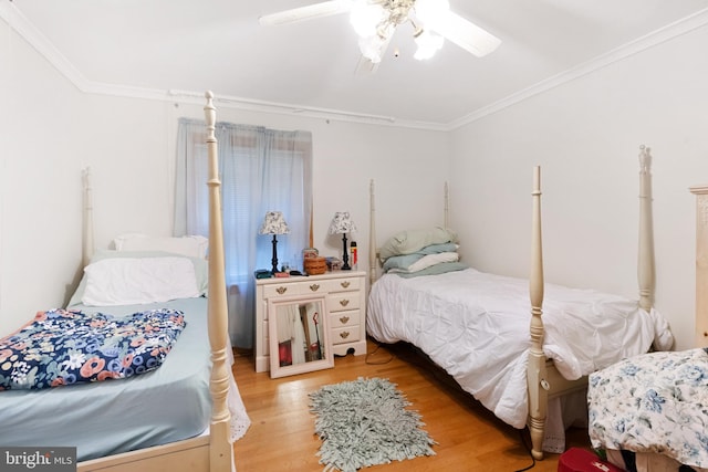 bedroom featuring ceiling fan, crown molding, and hardwood / wood-style flooring