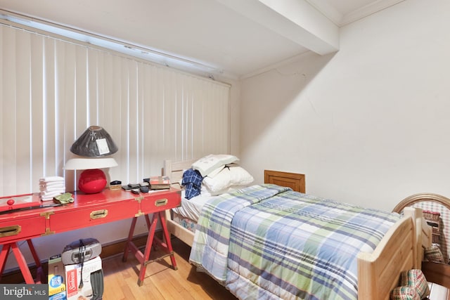 bedroom featuring crown molding and light hardwood / wood-style flooring