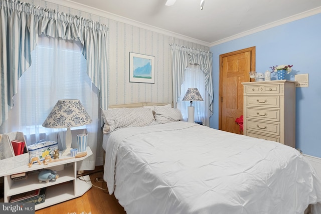 bedroom with multiple windows, ceiling fan, hardwood / wood-style floors, and ornamental molding