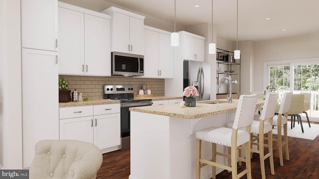 kitchen featuring pendant lighting, an island with sink, dark wood-type flooring, and appliances with stainless steel finishes