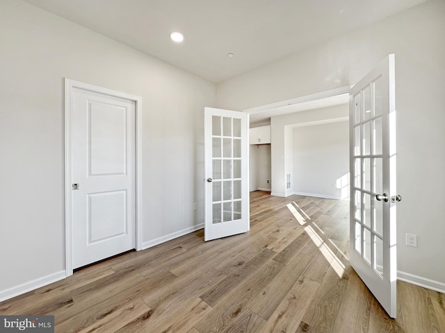 unfurnished room featuring light wood-type flooring and french doors