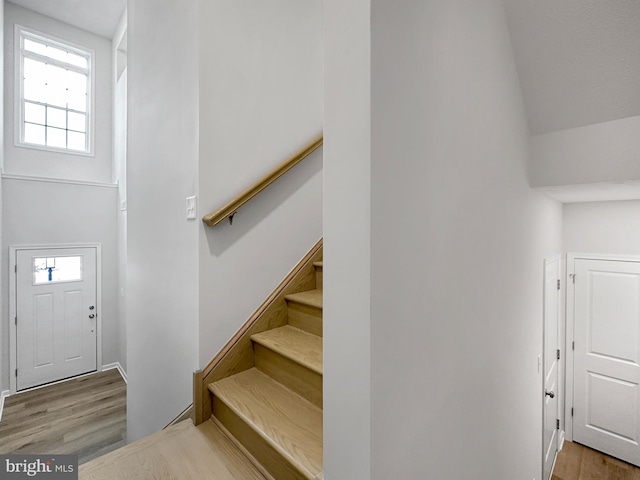 entryway with vaulted ceiling and light hardwood / wood-style flooring